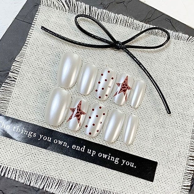 White press-on nails with star and dot designs in a clear case, branded 'DIARYNAILS'.